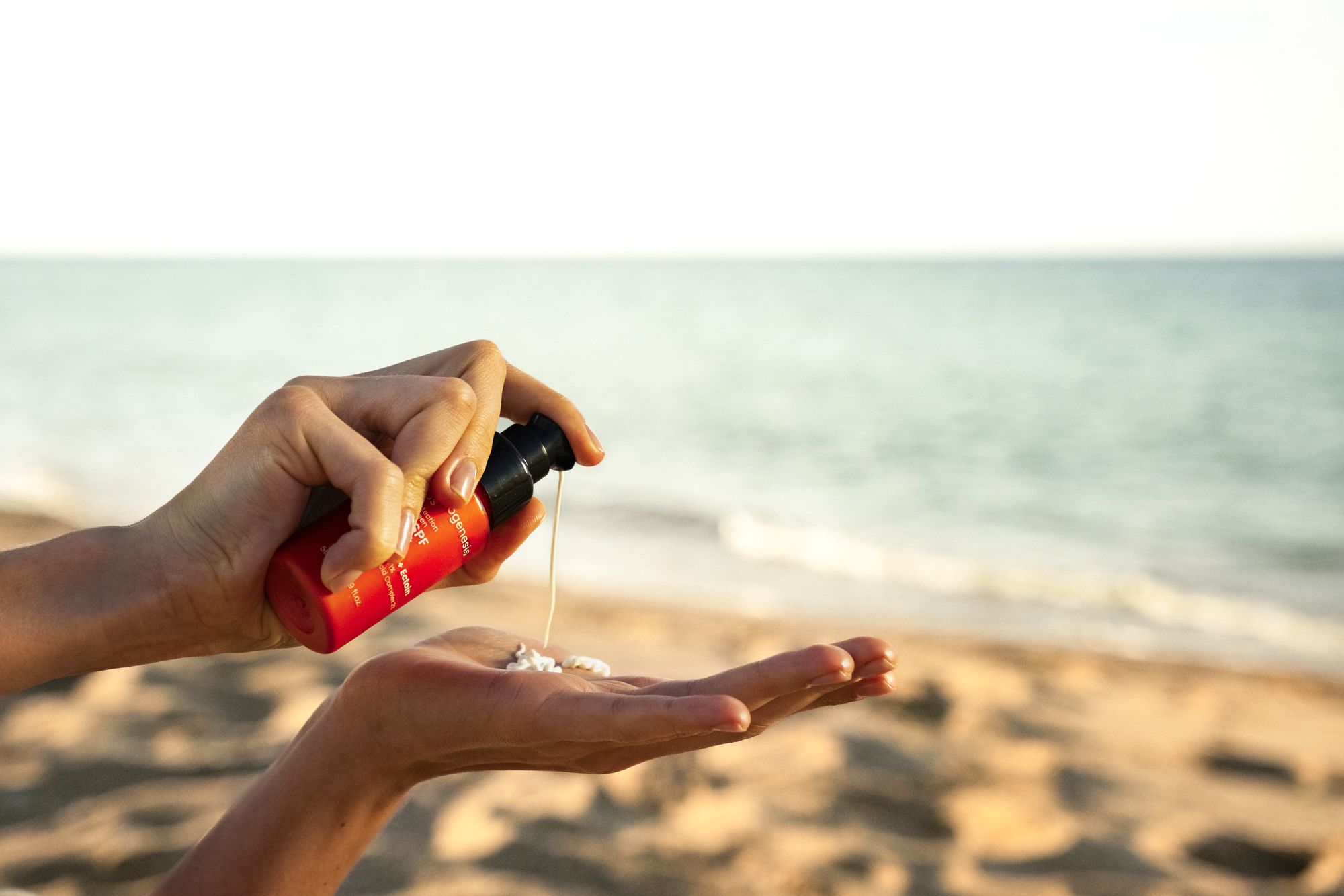 Applying a skincare product into the palm of the hand, by the sea